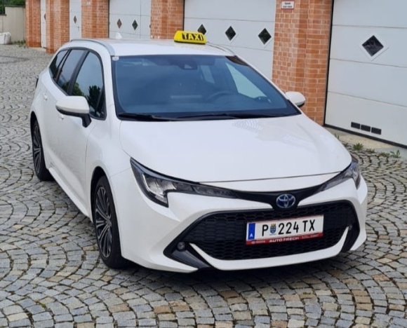 Taxi Kräftner 86100 Toyota Corolla Hybrid Kombi bei Garagen auf Kopfsteinpflaster